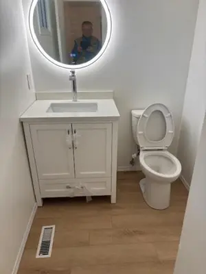 a bathroom with a sink and a toilet and a mirror at Kevin Calgary Beddington Home in Calgary