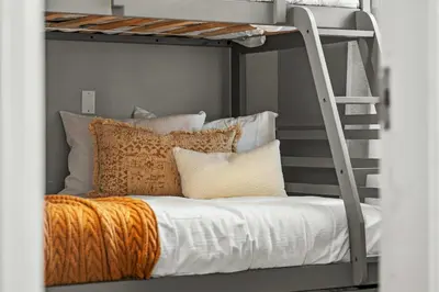 a bedroom with a bunk bed with pillows and a ladder at Sylvan Lake Nook Family-Friendly and Close to Beach in Sylvan Lake
