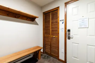 a room with a wooden door and a bench at 2BR in Gleneagle, Heated Flooring, Wood Burning Fireplace, Shuttle to Gondola in Whistler