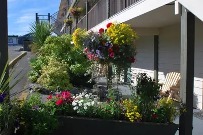 a flower garden on the side of a house at Pacific Rim Motel in Ucluelet