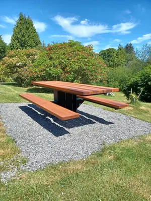 a wooden picnic table sitting on a pile of gravel at Pacific Rim Motel in Ucluelet