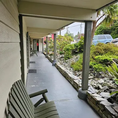 a porch with a bench on a house at Pacific Rim Motel in Ucluelet