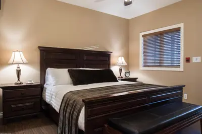 a bedroom with a bed and two lamps and a window at The Castle at Swan Lake in Vernon