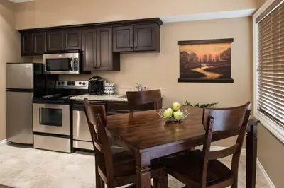 a kitchen with a wooden table with a bowl of fruit on it at The Castle at Swan Lake in Vernon