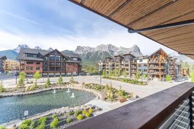 a view from the balcony of a resort with mountains at Modern Mountain Oasis Top floor 2 level 2bd in Canmore