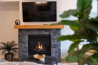 a fireplace with a television on top of it at Modern Mountain Oasis Top floor 2 level 2bd in Canmore