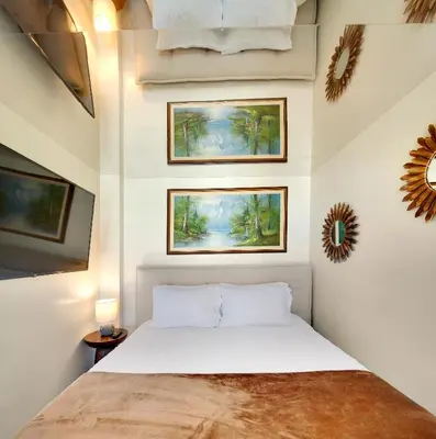 a bedroom with a bed and three paintings on the wall at Two-Story Loft with a High-rises view and Rooftop Deck in Vancouver