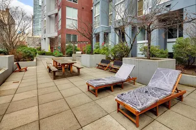 a patio with benches and tables and buildings at Two-Story Loft with a High-rises view and Rooftop Deck in Vancouver