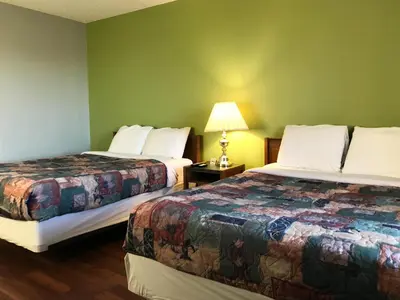 a hotel room with two beds and a lamp at Home Away Inn in Drayton Valley