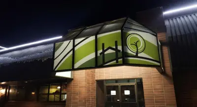 a building with a green sign on the side of it at Home Away Inn in Drayton Valley