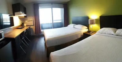 a hotel room with two beds and a window at Home Away Inn in Drayton Valley