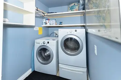 a washer and dryer in a blue laundry room at Salal Forest - 2 bedroom cabin in the forest in Tofino