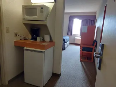 a hotel room with a microwave on a counter with a room at Tamarack Inn in Rocky Mountain House