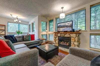 a living room with a fireplace and a tv at Greystone Lodge 224 Ski-in Out in Whistler