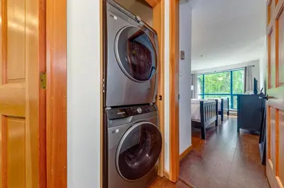a washer and dryer stacked in a room at Greystone Lodge 224 Ski-in Out in Whistler