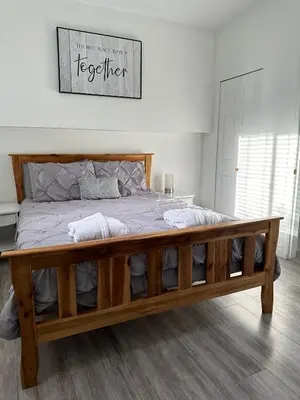 a bedroom with a large bed with a wooden frame at Westshore Garden Escape in Victoria