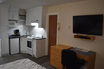 a small kitchen with a television on the wall at Canadas Best Value Inn & Suites-Castlegar in Castlegar