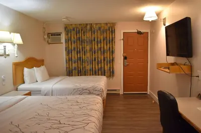 a hotel room with two beds and a flat screen tv at Canadas Best Value Inn & Suites-Castlegar in Castlegar