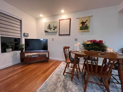 a living room with a table and a flat screen tv at Peter's Place - Spacious 2Bed & Bath Suite in Surrey