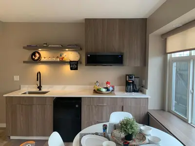 a kitchen with a sink and a table with chairs at The Scandinavian House by Maple Dream Homestay- near Sky train in Vancouver