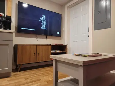 a living room with a tv on the wall at The Suite Treat in Whitehorse