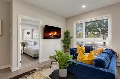 a living room with a blue couch and a fireplace at Pet Friendly 2 Bed Close to Downtown in Calgary