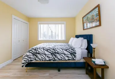 a bedroom with a bed and a window at 2 BR Spacious Ground Level Suite in Victoria