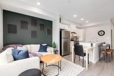 a living room with a white couch and a kitchen at Pet Friendly, Free Parking, Close to Downtown in Calgary