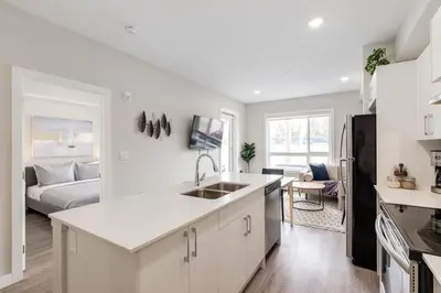 a kitchen with a sink and a living room at Pet Friendly, Free Parking, Close to Downtown in Calgary