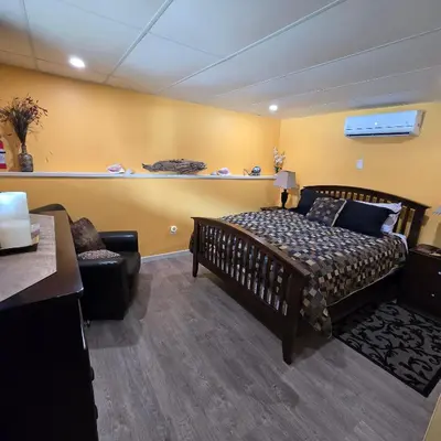 a bedroom with a bed and a couch and a chair at Ocean's Edge in Port Alice