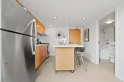 a kitchen with a stainless steel refrigerator and a sink at The Urban Lofts in Vancouver