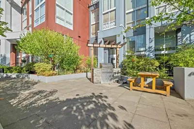 a bench and a table in front of a building at The Urban Lofts in Vancouver