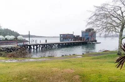 a dock on a body of water with houses on it at High Tide - Waterfront bachelor in Tofino
