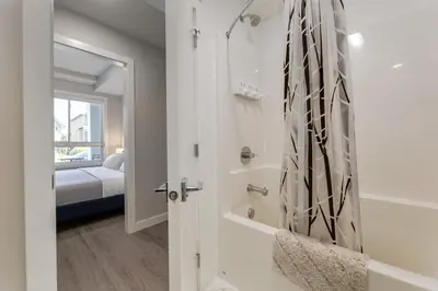 a bathroom with a shower and a tub at Free Underground Parking, Pet Friendly Apartment in Calgary