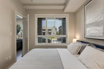 a bedroom with a large bed and a window at Free Underground Parking, Pet Friendly Apartment in Calgary