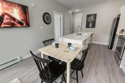 a kitchen with a table with chairs and a sink at Free Heated Parking, Quick DT Access in Calgary