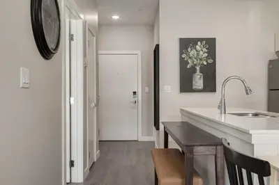 a kitchen with a sink and a counter with a table at Free Heated Parking, Quick DT Access in Calgary