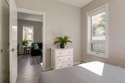 a bedroom with a bed and a dresser and a window at Free Heated Parking, Close to DT, Pet Friendly in Calgary