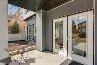 a patio with a table and a chair next to a house at Free Heated Parking, Close to DT, Pet Friendly in Calgary