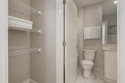 a white bathroom with a toilet and a shower at Free Heated Parking, Close to DT, Pet Friendly in Calgary