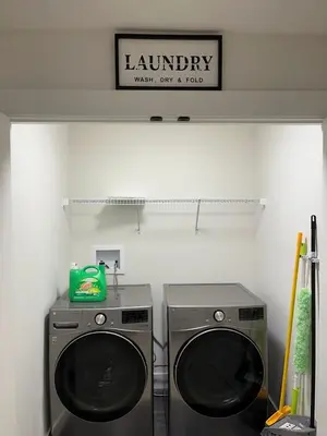 a laundry room with two washing machines and a sign at Luxurious, Centrally Located Home in Cavanagh in Edmonton