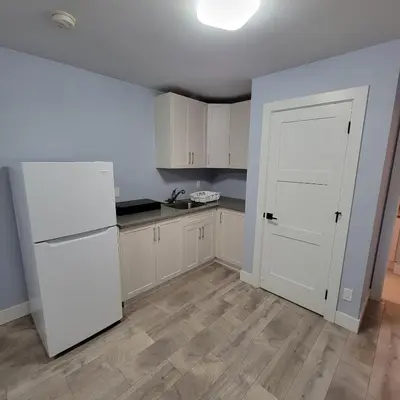 a kitchen with white appliances and a white door at Gladiola Bed & Breakfast in Victoria