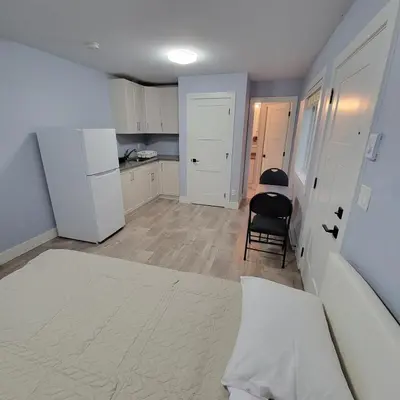 a kitchen with white cabinets and a table and a chair at Gladiola Bed & Breakfast in Victoria