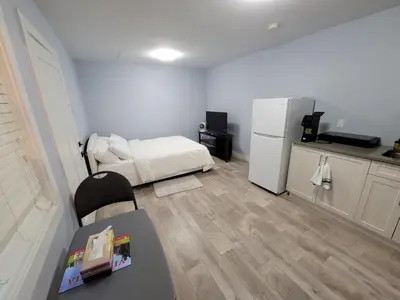 a small room with a bed and a refrigerator at Gladiola Bed & Breakfast in Victoria