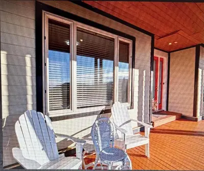 two chairs and a table on the porch of a house at Beaches Downtown Suite In Sechelt in Sechelt