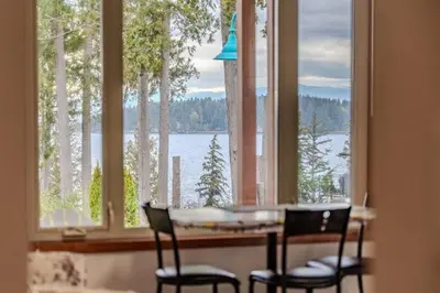 a kitchen with a table and chairs and a large window at Beaches Downtown Suite In Sechelt in Sechelt