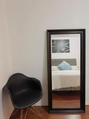 a black chair sitting in front of a mirror at Covepark house in Calgary