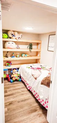 a bedroom with a bed and shelves with stuffed animals at Casa Andrei in Edmonton