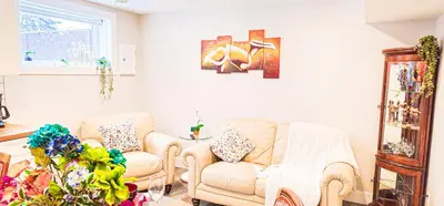 a living room with two chairs and a plant at Casa Andrei in Edmonton