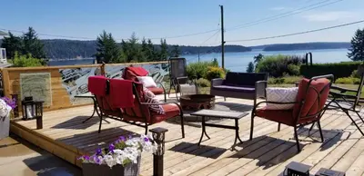 a deck with chairs and a view of the water at Cozy Quiet Suite with Private Hot Tub with Ocean Views in Nanaimo